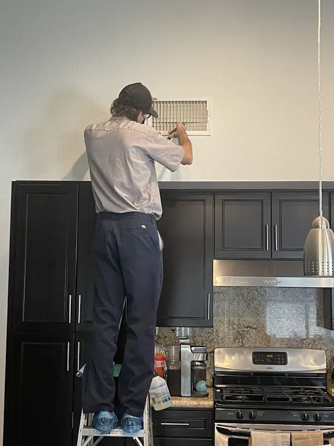 Technician inspecting an air vent during HVAC service in Ionia